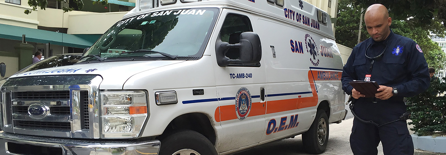 First responder using a tablet while standing next to an ambulance