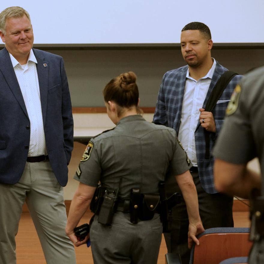 FirstNet Authority staff and Coverage Enhancement Workshop participants, including a uniformed law enforcement officer, stand in a circle speaking
