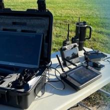 FirstNet-enabled devices on a table outside; Public Safety First podcast icon   
