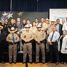 Texas first responders and hospital personnel and AT&T representatives stand in a group.