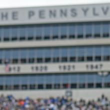Band member standing in Beaver Stadium during daytime