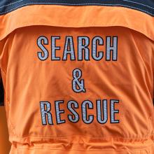 Search & Rescue jacket; attendees at 5x5: The Public Safety Innovation Summit listening to the Clearing the Air panel; Public Safety First podcast logo