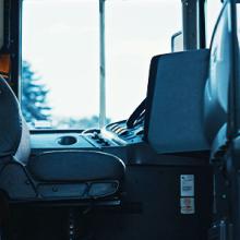 School bus with doors open showing the driver’s seat.