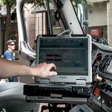 A paramedic using a laptop in the front seat of an ambulance