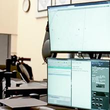 911 operator wearing a headset at a workstation with multiple screens