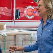 Getting the Most Out of FirstNet Boulder Fire-Rescue Chief Michael Calderazzo and FirstNet Authority Senior Public Safety Advisor Tracey Murdock stand talking in front of a fire truck