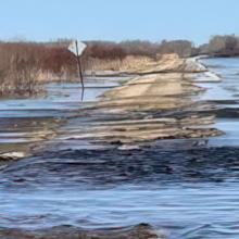 A road in Minnesota partially submerged in water from a recent flood. 