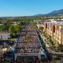 Runners at the BOLDERBoulder 10k road race in Boulder, Colorado; a Cell Booster Pro on a table.