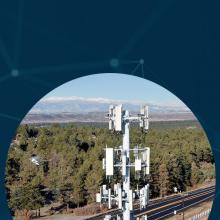 New Hampshire Public Safety Agencies Make the Case for Improved Broadband An interconnected network backdrop with three images of FirstNet towers, including a tower overlooking mountains, forest and a lake; a tower situated near a road and forest; and a FirstNet tower near a green open field surrounded by a dense forest.