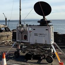Public safety in 2025: Rising to the challenges FirstNet Satellite Cell on Light Truck stationed next to Los Angeles Police Department vehicle in parking lot at night during 2025 Los Angeles wildfires; FirstNet Compact Rapid Deployable on a road next to a burned car and other fire debris with the ocean in the background during the 2025 Los Angeles wildfires.