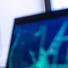 A Cell Booster Pro on a table next to two computers A Cell Booster Pro on a table next to two computers