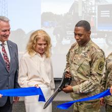 FirstNet is Transforming Communications for First Responders at U.S. Army Installation Fort Benning and Camp Frank D. Merrill in Georgia Fort Benning Garrison Commander Colonel Jerel Evans, along with representatives from the U.S. Army, FirstNet Authority, and AT&T, cuts a blue ribbon.