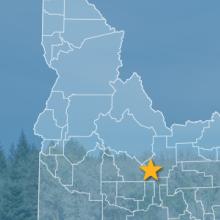 The State of Idaho, with outlined county borders and star locating Crater of the Moon National Monument, Idaho; a cell tower.