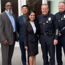 A group of FirstNet Authority, LAPD, and AT&T personnel posed in front of an LAPD office