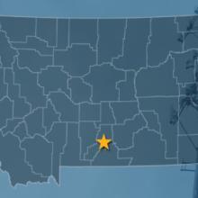 The state of Montana, with outlined county borders with a star locating Columbus, Montana; a cell tower.