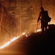 A firefighter monitors Sugar Pine/Miles Fire in Oregon at night. Photo credit: U.S. Forest Service – Pacific Northwest Region, July 30, 2018.