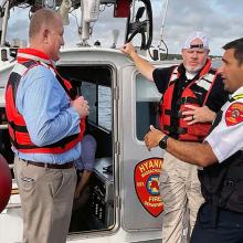 Public safety officials from Hyannis Fire speak with FirstNet Authority representatives while on an emergency response boat off the coast of Massachusetts.