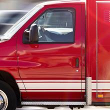 Red ambulance in motion with blurred road in background.