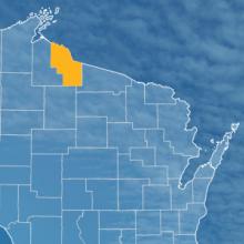 The state of Wisconsin, with outlined county borders; a cell tower.