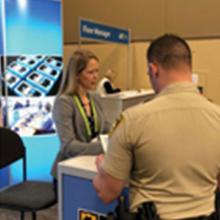 Edward Parkinson speaks to CES attendees; Bill Schrier gives a presentation; Chrissie Coon gives a presentation; two police offers visit the FirstNet exhibit booth; CES logo