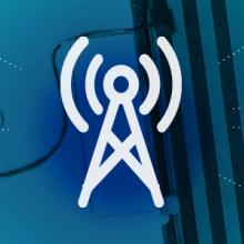 Roadmap Coverage and Capacity Domain icon (a broadband tower), surrounded by a graphic representation of a network radiating out, over an aerial view of a FirstNet SatCOLT 