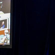 FirstNet Authority Board Chair Edward Horowitz stands behind a podium with a large screen featuring the FirstNet logo and images of first responders to his right.