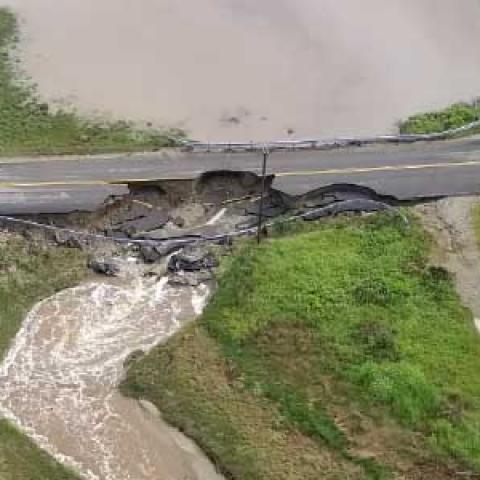Aerial view of pickup truck near washed out road and flooded grass
