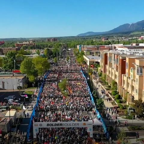 Runners at the BOLDERBoulder 10k road race in Boulder, Colorado; a Cell Booster Pro on a table.