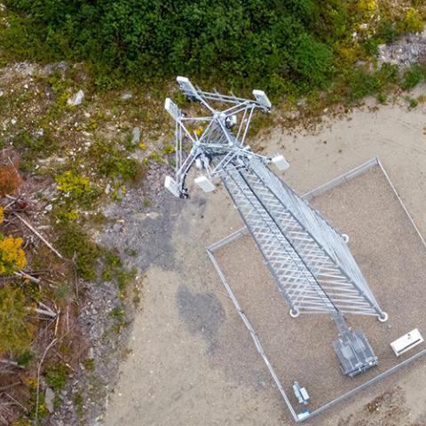 Overhead view of a Maine FirstNet cell tower in a rural area surrounded by trees.