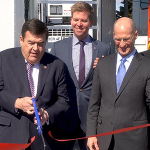 Congressman C.A. Dutch Ruppersberger cuts a red ribbon as FirstNet Authority Acting CEO Ed Parkinson looks on in front of an AT&T Satellite Cell on Light Truck
