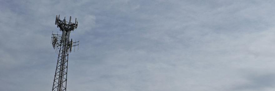 Cell tower against cloudy sky