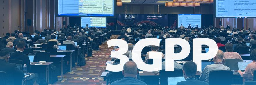 Attendees at the June 2026 3rd Generation Partnership Project plenary meeting sit in a conference room; large presentation screens show data
