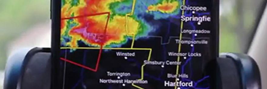 Close up of a phone displaying storm maps in Connecticut