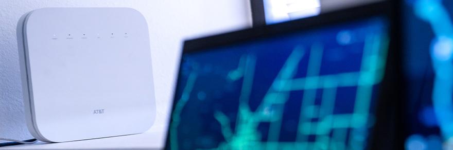 A Cell Booster Pro on a table next to two computers