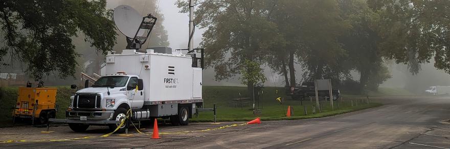 A FirstNet SatCOLT set up along a rural street on a foggy day.