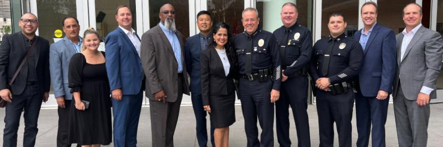 A group of FirstNet Authority, LAPD, and AT&T personnel posed in front of an LAPD office