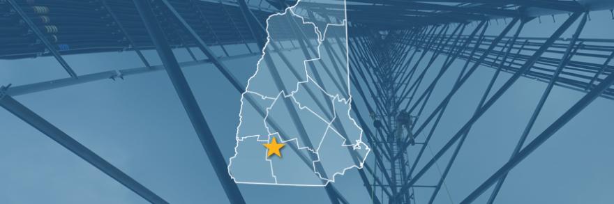 The State of New Hampshire, with outlined county borders and star locating Antrim, New Hampshire; a cell tower.