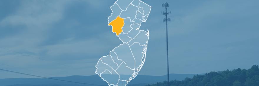 The state of New Jersey, with outlined county borders; a cell tower.