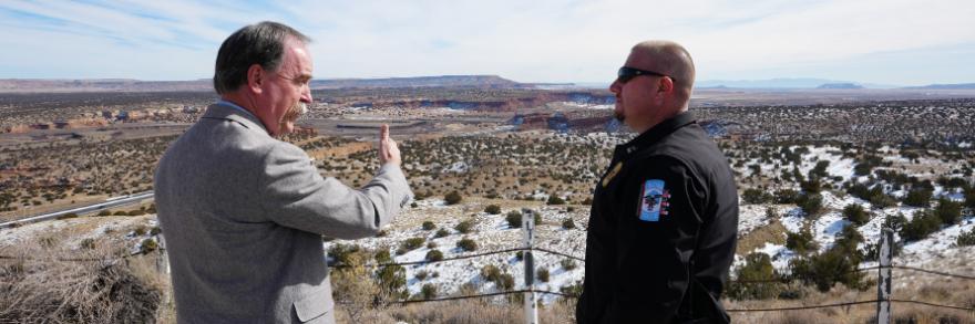 A public safety officer and a FirstNet Authority staff member speak with each other overlooking a Navajo reservation