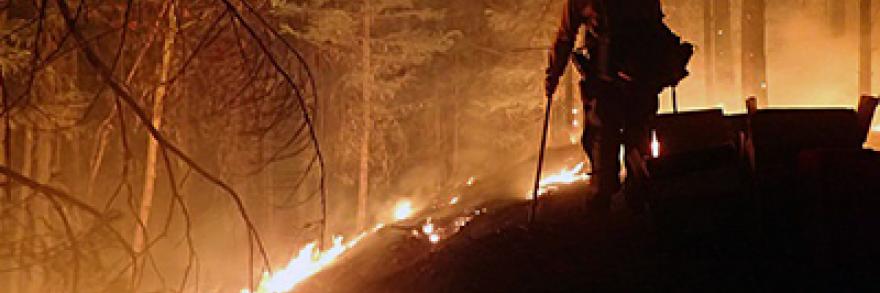 A firefighter monitors Sugar Pine/Miles Fire in Oregon at night. Photo credit: U.S. Forest Service – Pacific Northwest Region, July 30, 2018.