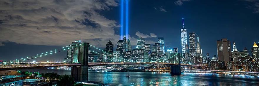 New York City skyline with two beams of light in the sky marking September 11 remembrance 