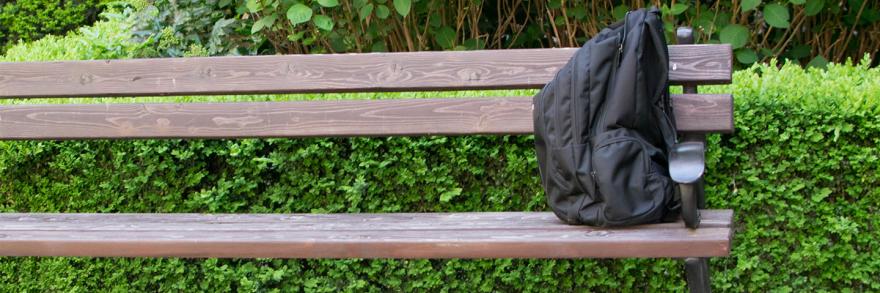 A backpack on a bench in a park