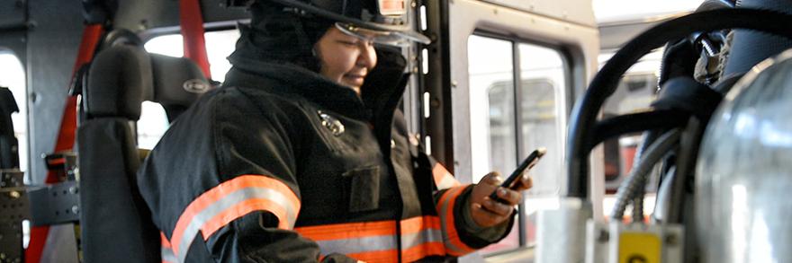 Firefighter using smartphone inside firetruck