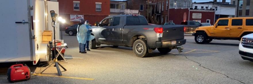 Medical professionals stand by a pickup truck at a COVID-19 testing site.