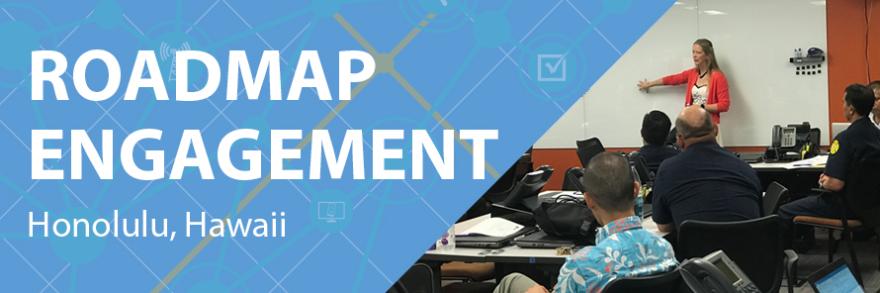 On left a graphic overlay representing a network and engagement, attendees listen to Jennifer Harder of the FirstNet Authority who stands at the front of the room using a whiteboard.