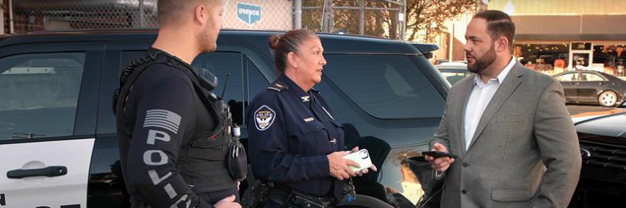 Ironton Police Department Chief Pamela Wagner and an Ironton police officer talk with Ironton Mayor Sam Cramblit outside of a police SUV cruiser.