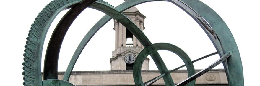 The Old Main Bell Tower sits behind the Old Main Armillary Sphere on the Pennsylvania State University campus.