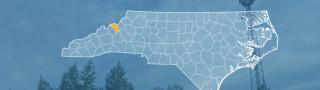 The state of North Carolina, with outlined county borders; a cell tower.