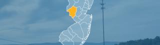 The state of New Jersey, with outlined county borders; a cell tower.
