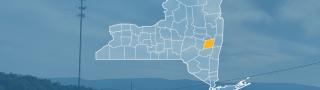 The state of New York, with outlined county borders; a cell tower.